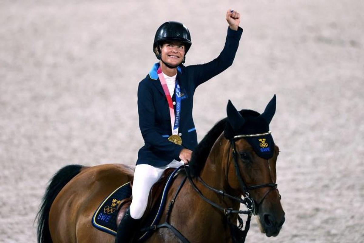 (L-R) Gold medalist, Sweden Malin Baryard-Johnsson parades with Indiana after the medal ceremony of the equestrian's jumping team during the Tokyo 2020 Olympic Games at the Equestrian Park in Tokyo on August 7, 2021. Behrouz MEHRI / AFP