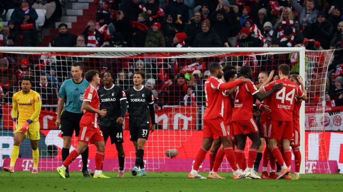 Bayern Munich's players celebrate scoring their team's second goal scored by Bayern Munich's French midfielder #17 Michael Olise during the German first division Bundesliga football match between FC Bayern Munich and SC Freiburg in Munich, southern Germany on November 22, 2025. Karl-Josef HILDENBRAND / AFP