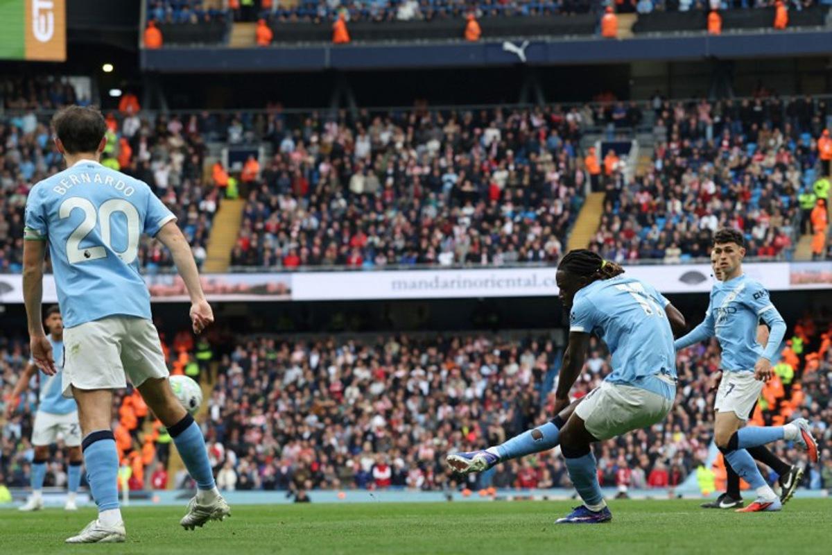 Manchester City's Belgian midfielder #11 Jeremy Doku (2R) shoots to score the opening goal during the English Premier League football match between Manchester City and Brentford at the Etihad Stadium in Manchester, north west England, on May 9, 2026. Darren Staples / AFP