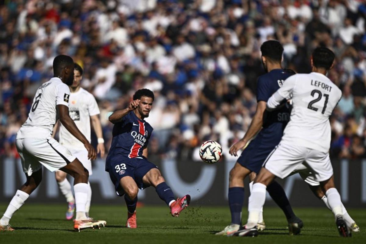 Paris Saint-Germain's French midfielder #33 Warren Zaire-Emery (C) kicks the ball during the French L1 football match between Paris Saint-Germain (PSG) and SCO Angers at The Parc des Princes Stadium in Paris on April 5, 2025. JULIEN DE ROSA / AFP