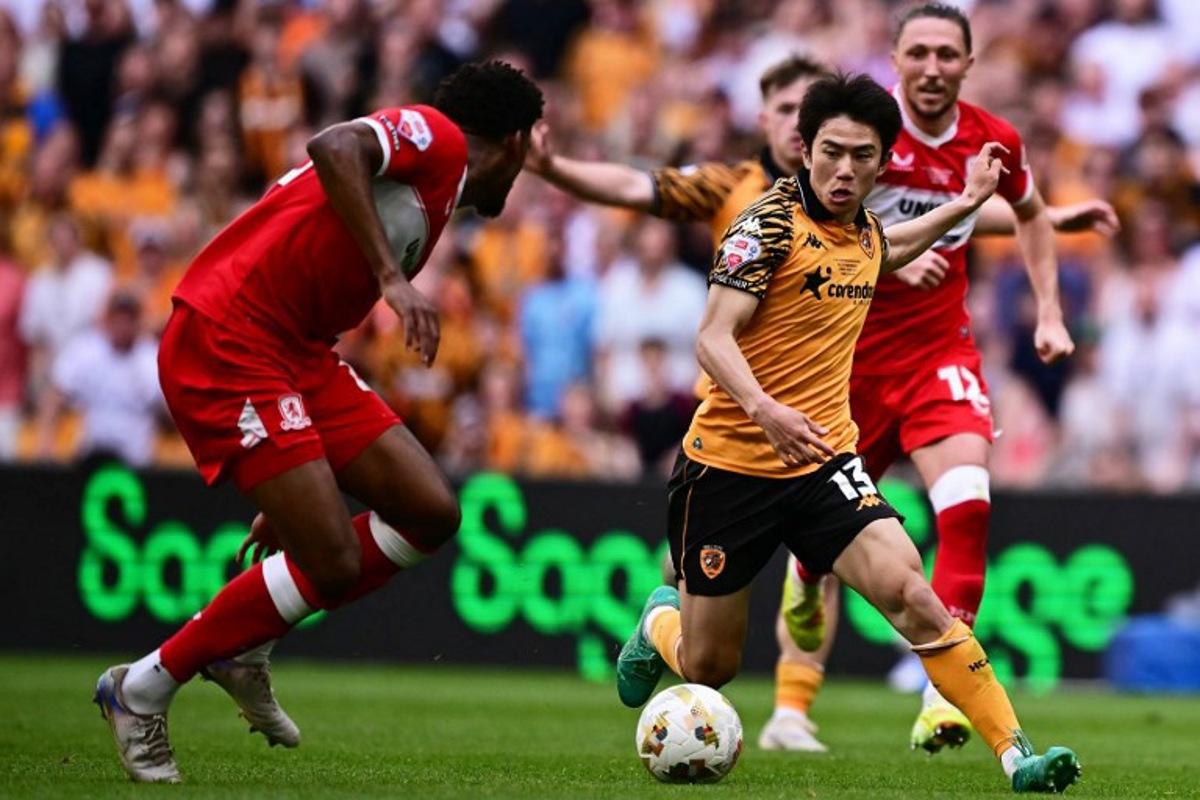 Hull City's Japanese midfielder #13 Yu Hirakawa runs with the ball during the English Championship play-off final football match between Hull City and Middlesbrough at Wembley Stadium in London on May 23, 2026. Ben STANSALL / AFP