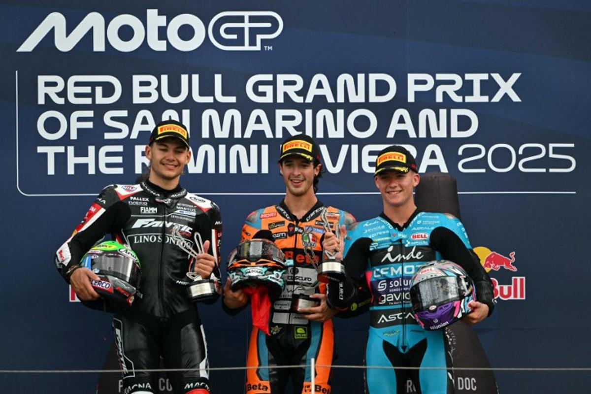 First placed Folladore SpeedRS Team's Italian Moto2 rider Celestino Vietti (C) stands on the podium next to Fantic Racing Lino Sonego team's Belgian Moto2 rider Barry Baltus (L) and thrid placed CFMOTO Inde Aspar Team's Spanish Moto2 rider Daniel Holgado (R) at the end of the Moto2 race as part of the San Marino Moto GP at the Misano World Circuit Marco Simoncelli, in Misano Adriatico, northern Italy, on September 14, 2025. Andreas SOLARO / AFP
