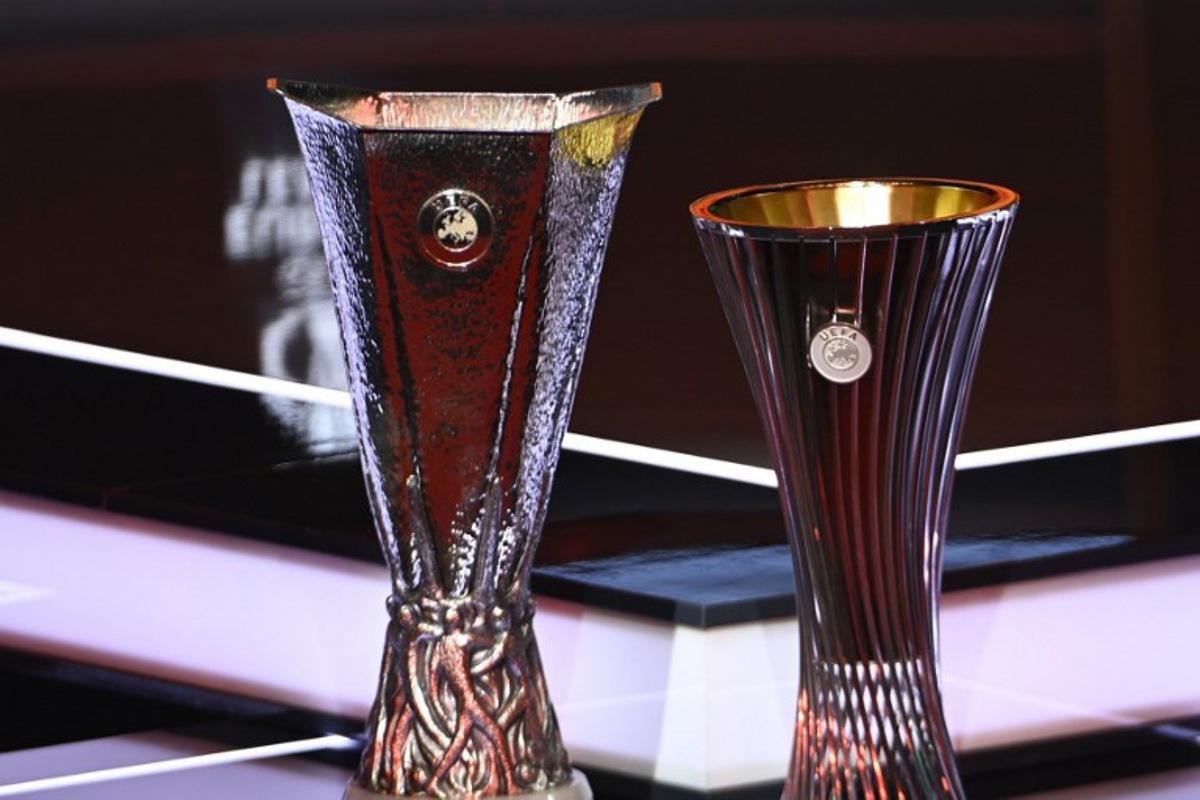 This photograph shows the competitions trophies displayed on set ahead of the draw ceremony for the group stage of the 2025-2026 UEFA Europa League and Conference League tournaments, at the Grimaldi forum in Monaco on August 29, 2025. Frederic DIDES / AFP