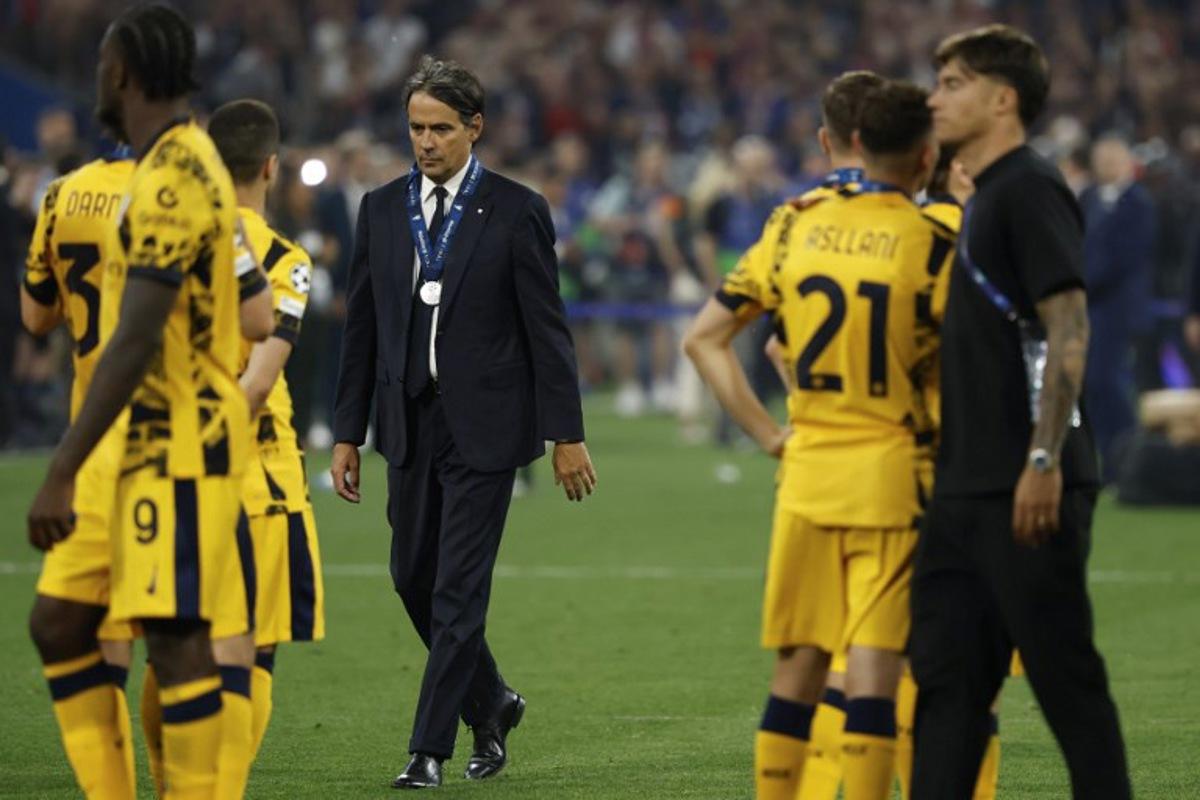 Inter Milan's Italian head coach Simone Inzaghi walks away with his runner-up medal at the end of the UEFA Champions League final football match between Paris Saint-Germain (PSG) and Inter Milan in Munich, southern Germany on May 31, 2025. Paris Saint-Germain won the Champions League for the first time by thrashing Inter Milan 5-0 in the most one-sided final in the competition's history. Odd ANDERSEN / AFP