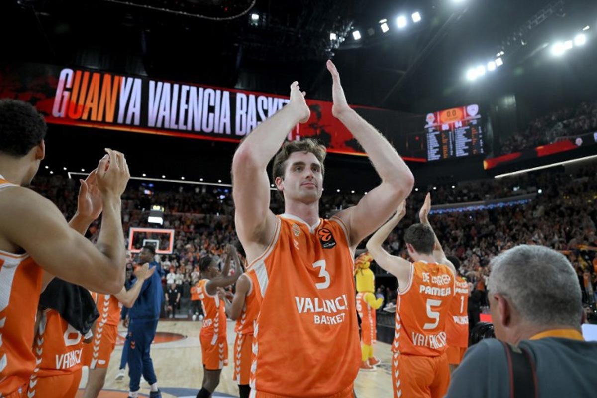 Valencia's players celebrate with supporters their victory 85-84 at the end of the Euroleague basketball match between Valencia Basket and Olympiacos at the Roig arena in Valencia on March 24, 2026. Jose JORDAN / AFP