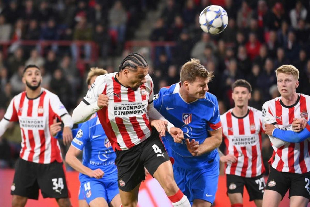 PSV Eindhoven's Dutch defender #04 Armando Obispo heads the ball during the UEFA Champions League, league phase day 6, football match between PSV Eindhoven (NED) and Atletico Madrid (ESP), at the Philips Stadion, in Eindhoven, south of The Netherlands, on December 9, 2025. JOHN THYS / AFP