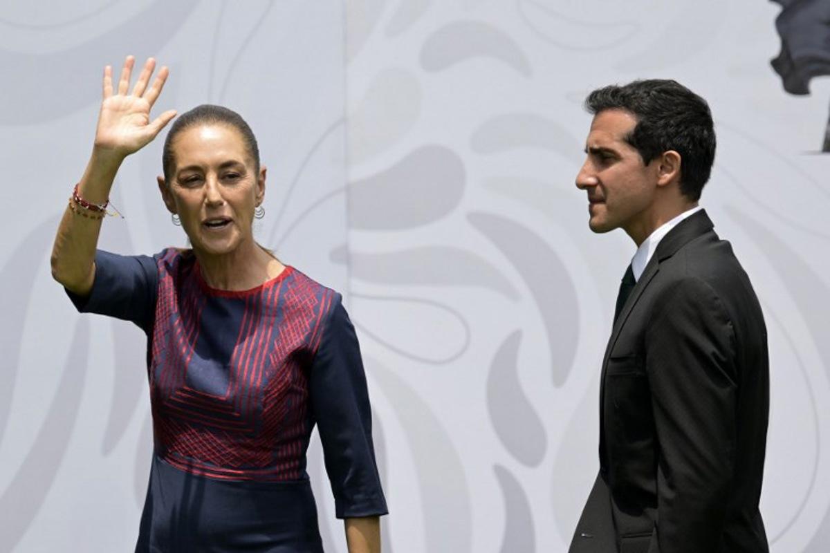 Mexico's President Claudia Sheinbaum waves next to Mexico's National Commission for Physical Culture and Sport (CONADE) director Rommel Pacheco, during the flag presentation ceremony for the Mexican national football team ahead of the FIFA 2026 World Cup at the Centro de Alto Rendimiento in Mexico City on June 8, 2026. Alfredo ESTRELLA / AFP