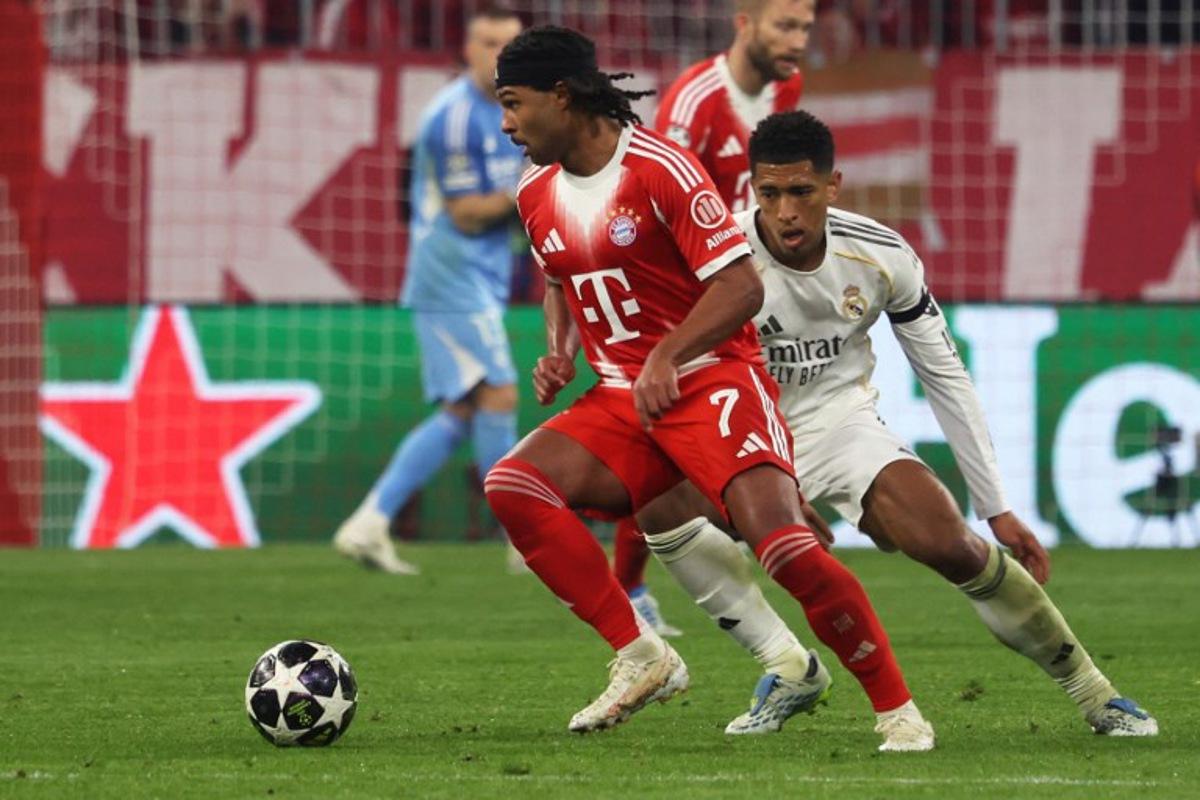 Real Madrid's English midfielder #05 Jude Bellingham (R) and Bayern Munich's German forward #07 Serge Gnabry vie for the ball during the UEFA Champions League quarter-final second leg football match between FC Bayern Munich and Real Madrid in Munich, southern Germany, on April 15, 2026. Karl-Josef HILDENBRAND / AFP