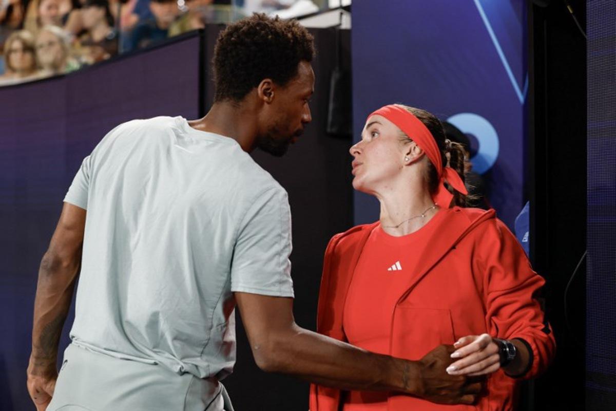 France's Gael Monfils (L) embraces his wife Ukraine's Elina Svitolina following her victory against Italy's Jasmine Paolini in their women's singles match on day seven of the Australian Open tennis tournament in Melbourne on January 18, 2025. Martin KEEP / AFP