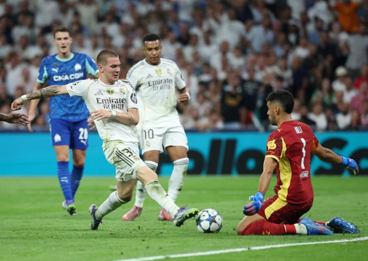 Real Madrid's Argentine forward #30 Franco Mastantuono challenges Marseille's Argentine goalkeeper #01 Geronimo Rulli during the UEFA Champions League first round day 1 football match between Real Madrid CF and Olympique de Marseille at the Santiago Bernabeu stadium in Madrid on September 16, 2025. Pierre-Philippe MARCOU / AFP