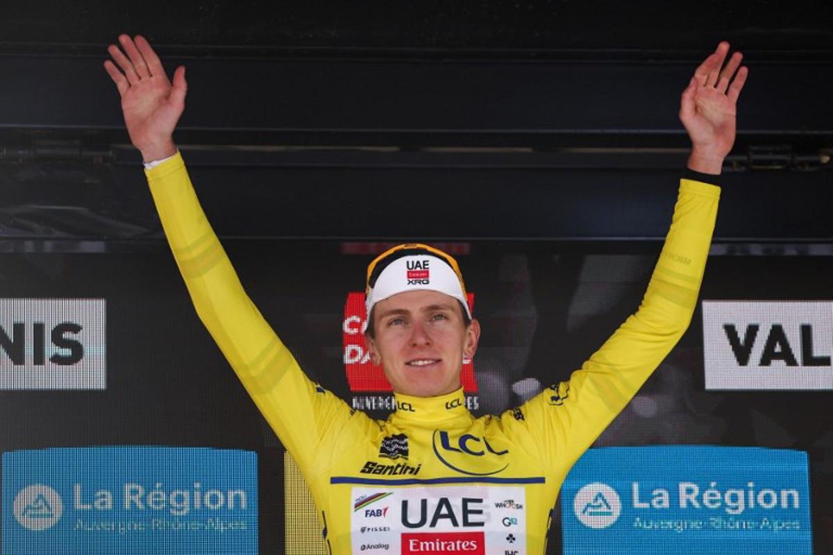 UAE Team Emirates XRG's Slovenian rider Tadej Pogačar wearing the overall leader's yellow jersey celebrates winning the overall race on the podium of the 8th and final stage of the 77th edition of the Criterium du Dauphine cycling race, 133,3 km between Val-d'Arc and Val-Cenis - Plateau du Mont Cenis, on June 15, 2025. Anne-Christine POUJOULAT / AFP