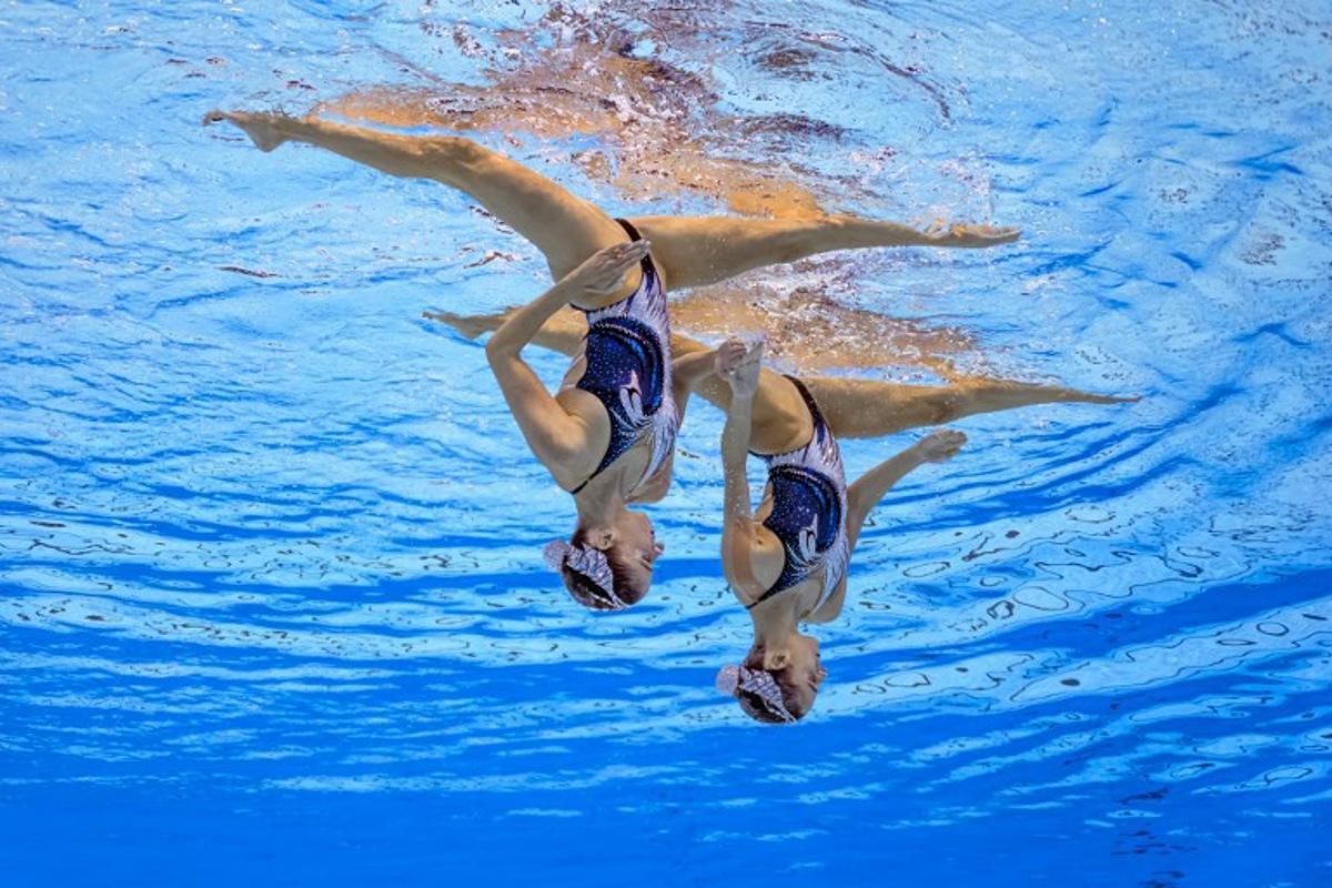 Austria's artistic swimmer Anna-Maria Alexandri and Austria's artistic swimmer Eirini-Marina Alexandri compete in the final of the women's duet technical artistic swimming event during the 2025 World Aquatics Championships in Singapore on July 21, 2025. FRANCOIS-XAVIER MARIT / AFP