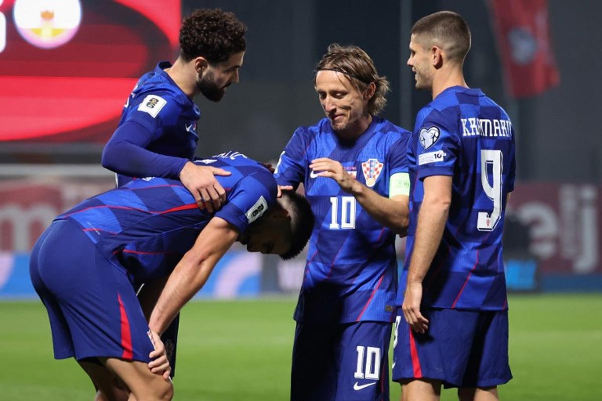 Croatia's defender #05 Martin Erlic (C) is congratulated by Croatia's defender #04 Josko Gvardiol (L, Croatia's midfielder #10 Luka Modric (2ndR) and Croatia's forward #09 Andrej Kramaric (R) after scoring his team's third goal during the FIFA World Cup 2026 Group L European qualification football match between Croatia and Gibraltar at the Maksimir Stadium in Zagreb, on October 12, 2025. STRINGER / AFP