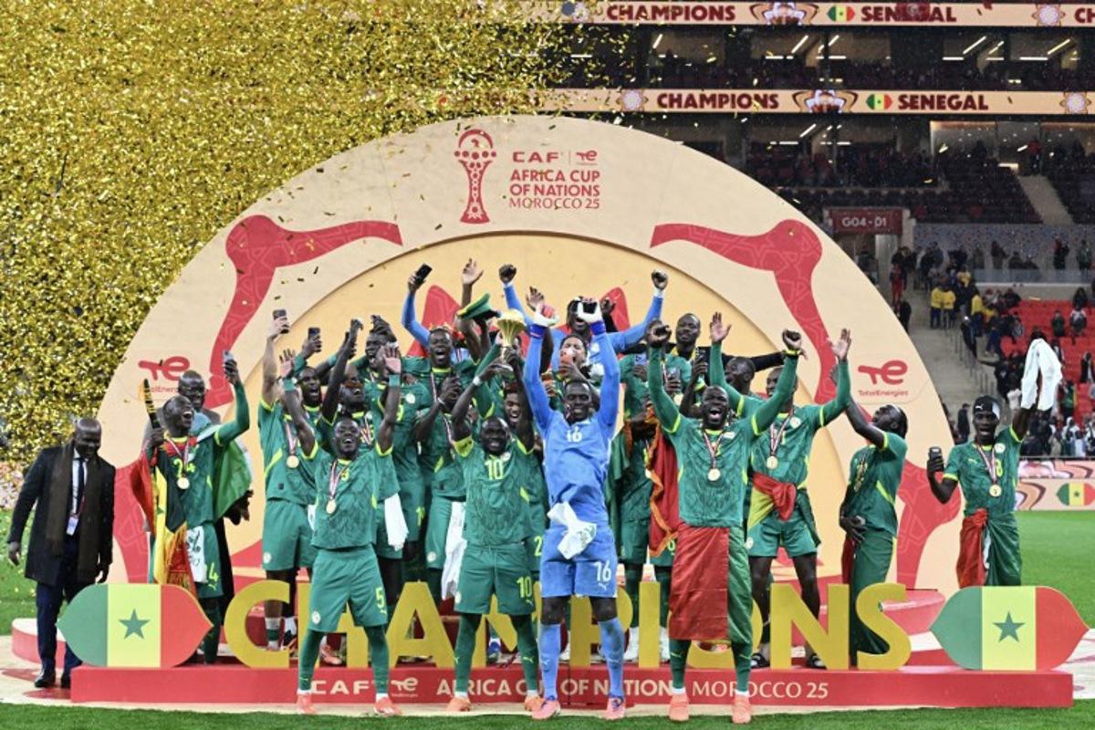 Senegal's forward #10 Sadio Mane holds up the trophy as he celebrates with his teammates after winning the Africa Cup of Nations (CAN) final football match between Senegal and Morocco at the Prince Moulay Abdellah Stadium in Rabat on January 18, 2026. SEBASTIEN BOZON / AFP