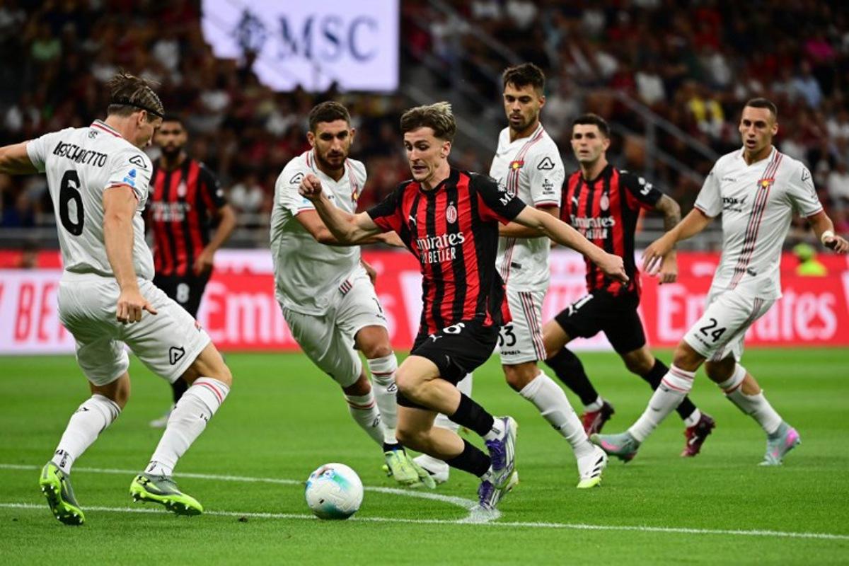 Cremonese's Italian defender #06 Federico Baschirotto (L) fights for the ball with AC Milan's Begian midfielder #56 Alexis Saelemaekers (C) during the Italian Serie A football match between AC Milan and Cremonese at San Siro stadium in Milan, on August 23, 2025. PIERO CRUCIATTI / AFP