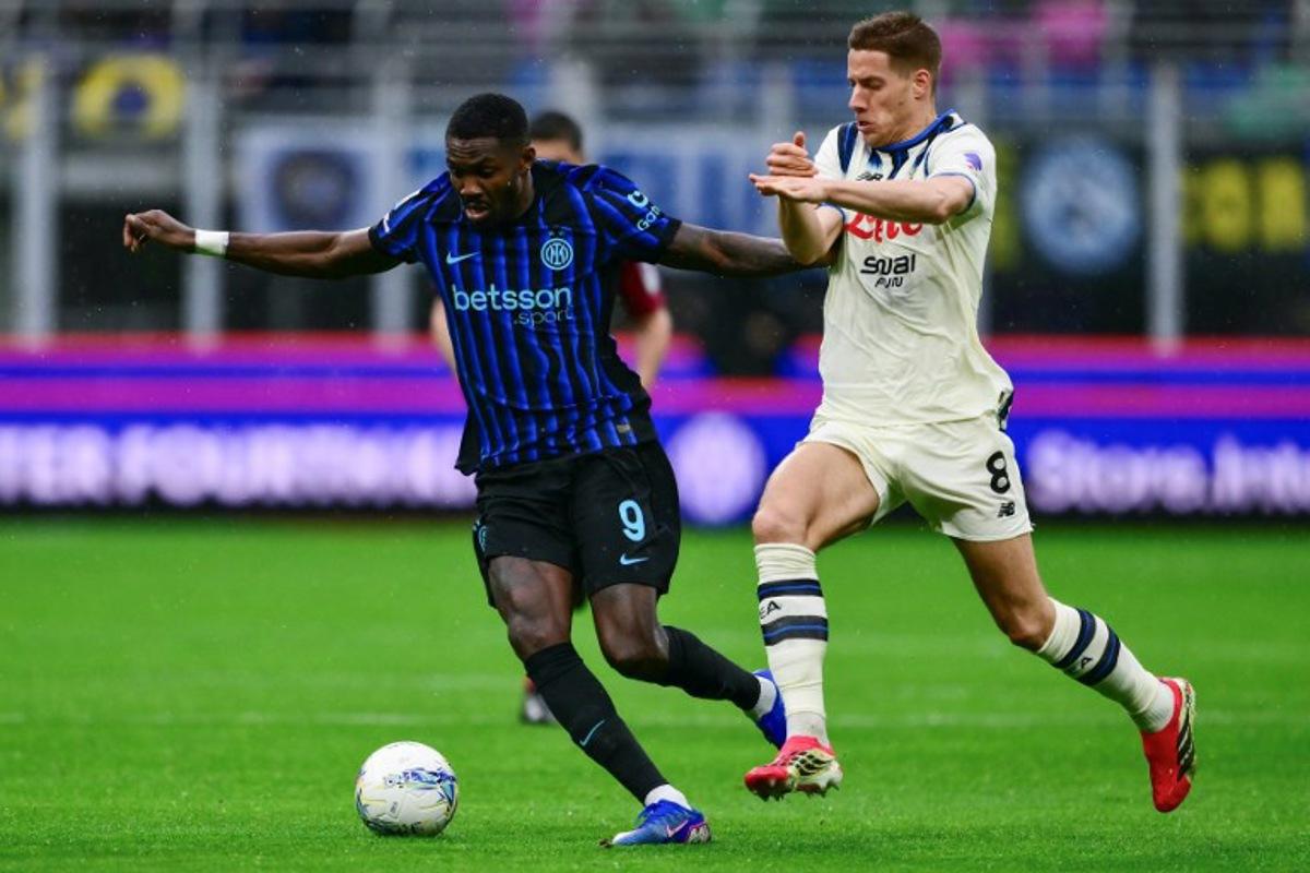 Inter Milan's French forward #9 Marcus Thuram (L) fights for the ball with Atalanta's Croatian midfielder #8 Mario Pasalic during the Italian Serie A football match between Inter Milan and Atalanta at the San Siro stadium in Milan on March 14, 2026. MARCO BERTORELLO / AFP