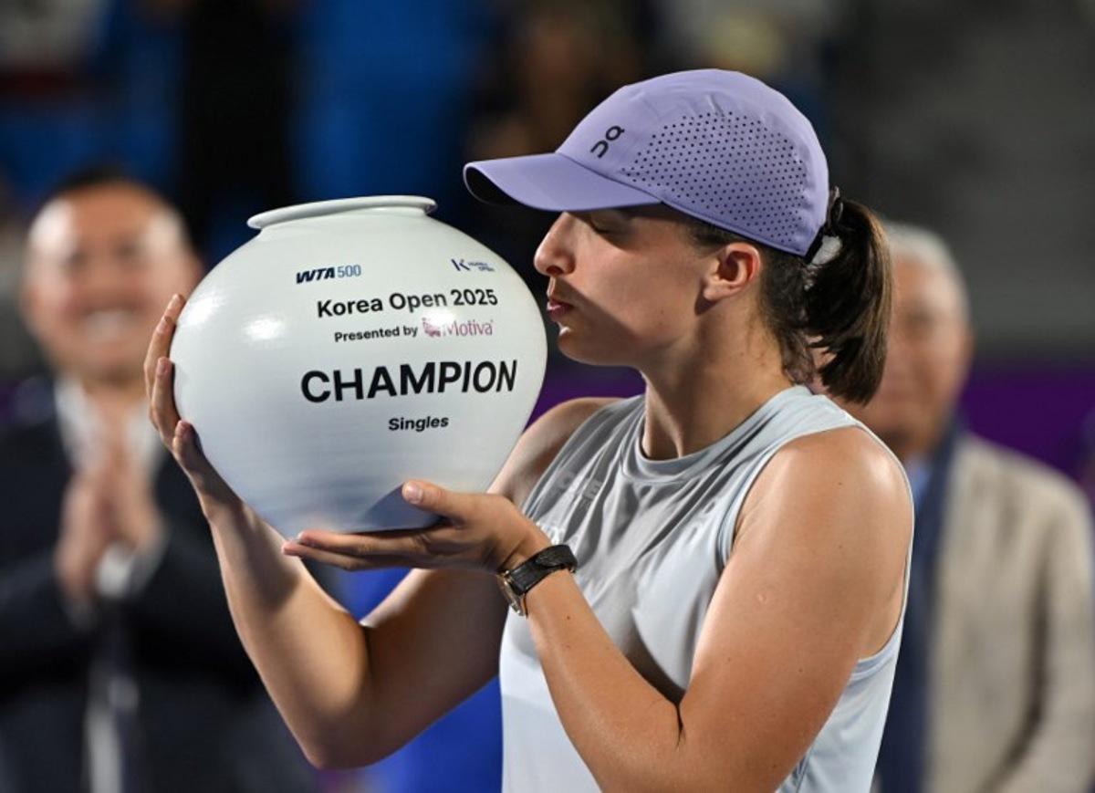 Iga Swiatek of Poland celebrates with the trophy after beating Ekaterina Alexandrova of Russia to win the women's singles final match at the Korea Open tennis tournament in Seoul on September 21, 2025. Jung Yeon-je / AFP