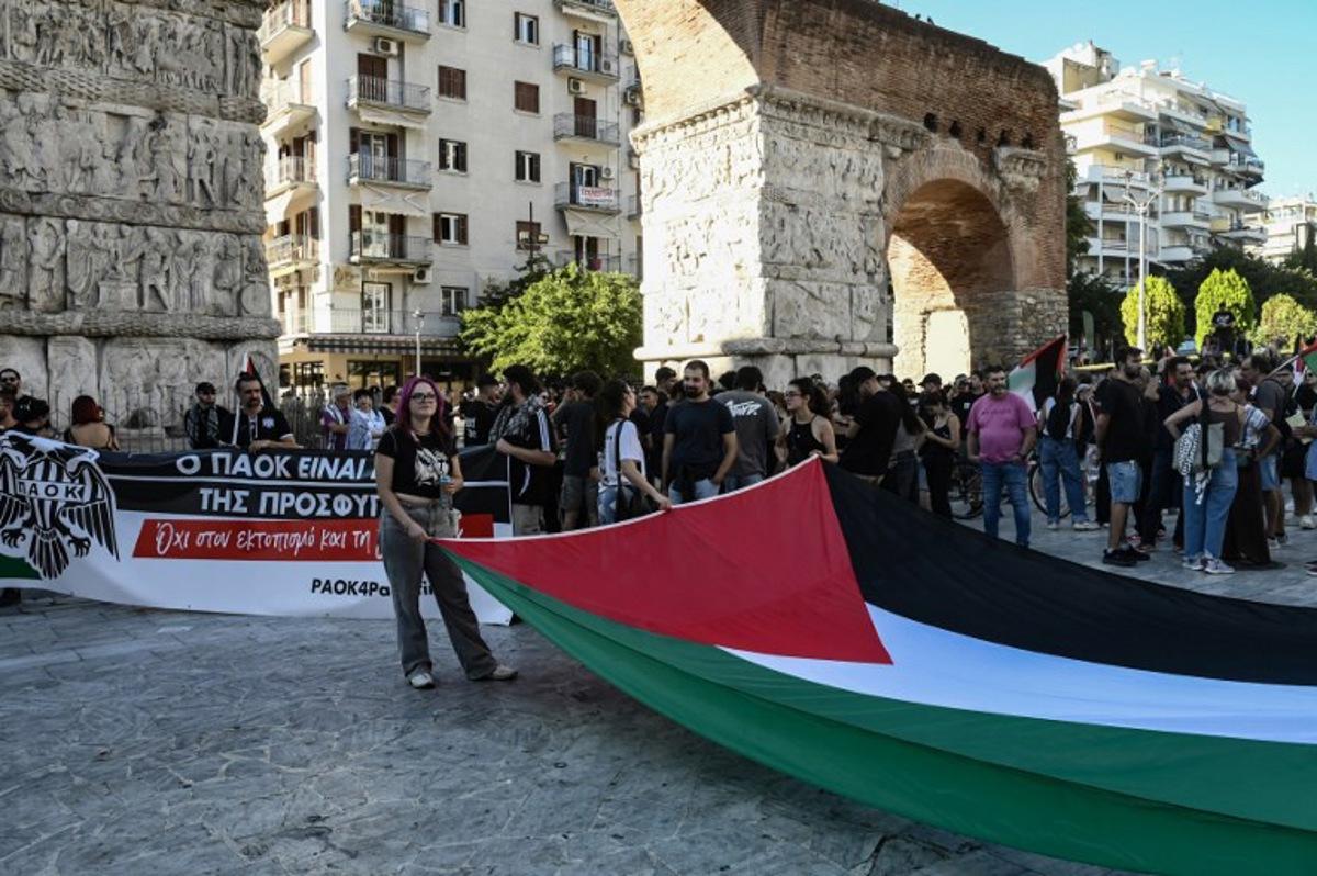 PAOK's supporters hold a Palestinian flag as they protest next to Arch of Galerius, in solidarity with Palestinians in Gaza before the UEFA Europa League football match day 1, between PAOK Saloniki and Maccabi Tel-Aviv in Thessaloniki, on September 24, 2025. Sakis Mitrolidis / AFP