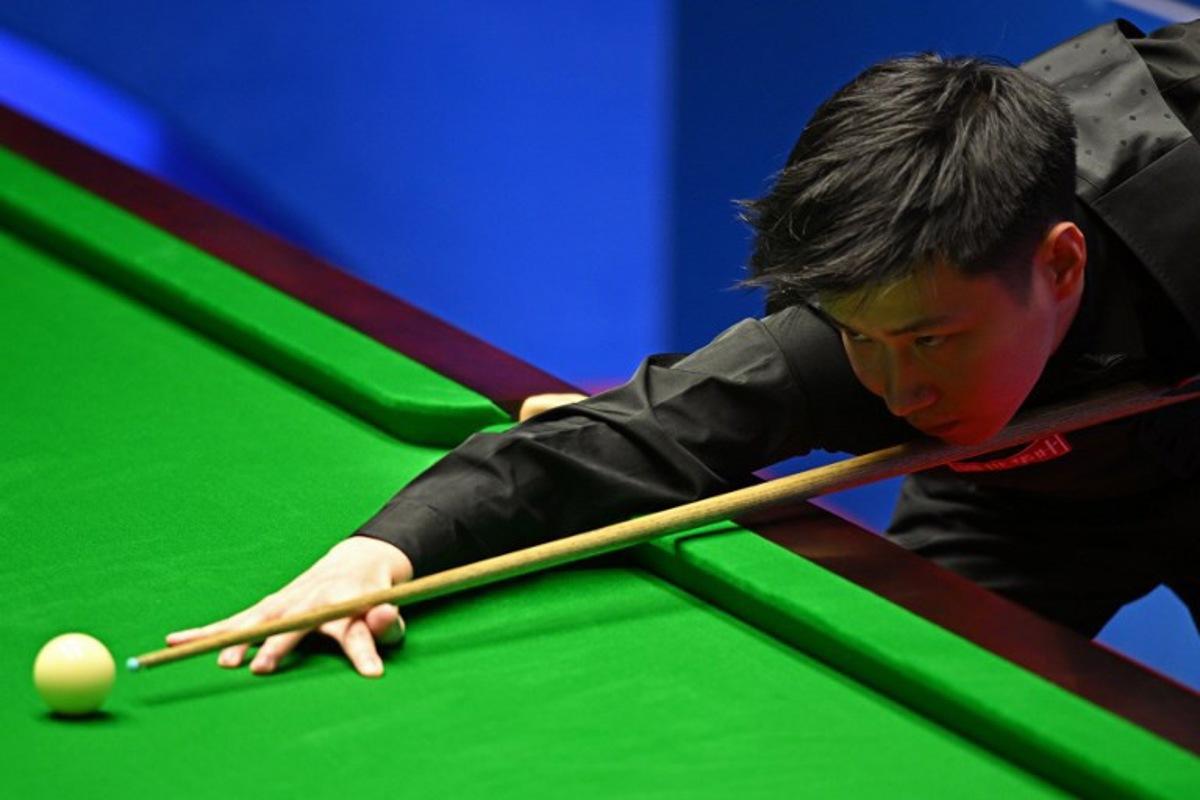 China's Zhao Xintong plays a shot against Scotland's Stephen Maguire during their World Championship Snooker second round match at The Crucible in Sheffield, England on April 22, 2022. Oli SCARFF / AFP