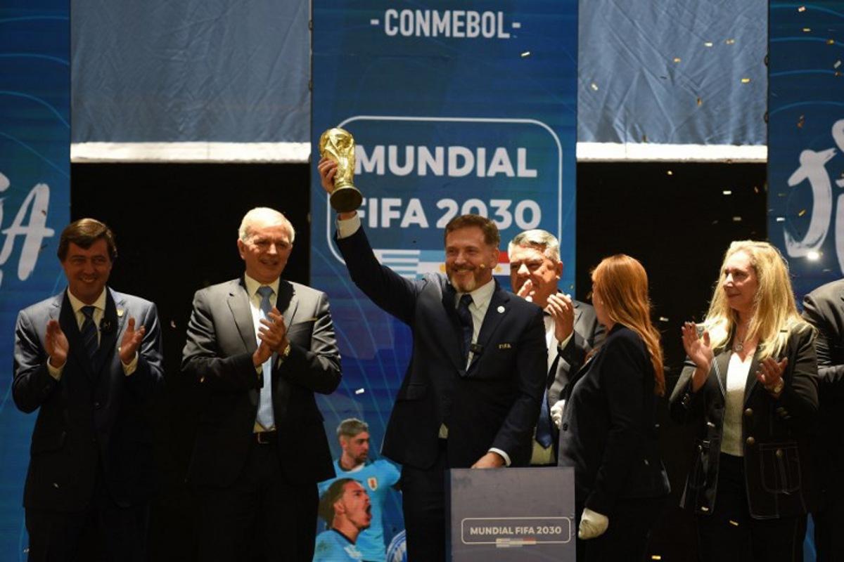 CONMEBOL President Paraguayan Alejandro Dominguez holds a replica of the FIFA World Cup as he celebrates the ratification of Argentina, Paraguay, and Uruguay as host countries of the FIFA 2030 World Cup during the FIFA virtual Congress in Luque, Paraguay, on December 11, 2024. A virtual Congress of world football's governing body confirmed that Morocco, Spain and Portugal will be joint hosts of the 2030 World Cup, which will also see three games played in South America. The 2030 tournament will mark a century since the first World Cup was held in Uruguay, and as a result the unrivalled joint bid by Morocco, Spain and Portugal will also see the South American nation handed one game along with Argentina and Paraguay. DANIEL DUARTE / AFP