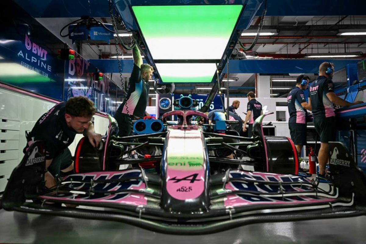Mechanics work on the car of Alpine's French driver Pierre Gasly in the garage before the second practice session ahead of the Formula One Singapore Grand Prix night race at the Marina Bay Street Circuit in Singapore on October 3, 2025. MOHD RASFAN / AFP