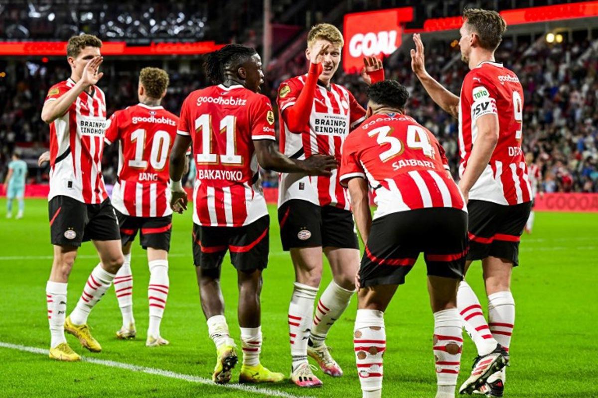 PSV's players celebrate after scoring their fifth goal during the Dutch Eredivisie fooball match between PSV Eindhoven and Almere City FC at the Phillips Stadium in Eindhoven on April 12, 2025. Olaf Kraak / ANP / AFP