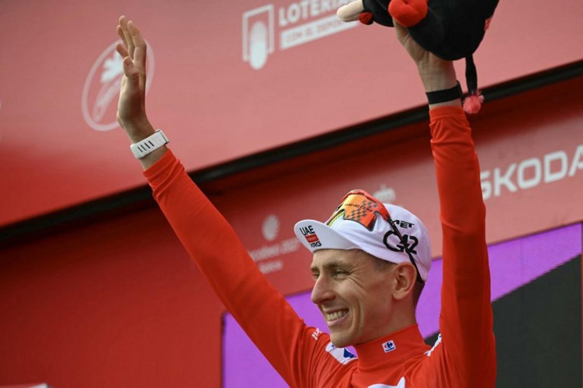 Overall race leader, UAE Team Emirates - XRG team's Slovenian rider Tadej Pogacar, gestures on the podium after the seventh stage of the Vuelta a Espana 2026, a 149,8 km race between Vall d'Alba and Aramon Valdelinares on August 28, 2026. JOSE JORDAN / AFP