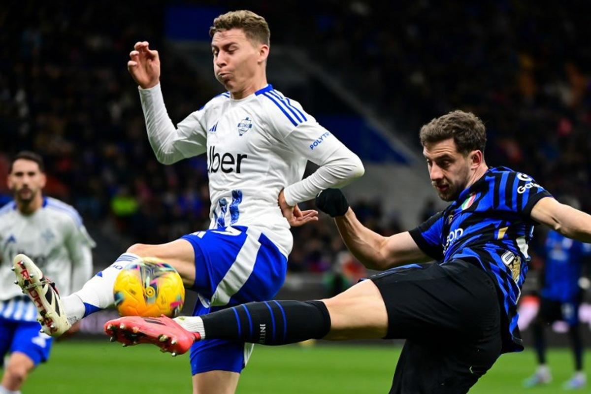Inter Milan's Brazilian defender #30 Carlos Augusto (R) shoots the ball past Como's Belgian defender #77 Ignace Van der Brempt during the Italian Serie A football match between Inter Milan and Como at the San Siro Stadium in Milan on December 23, 2024. Piero CRUCIATTI / AFP