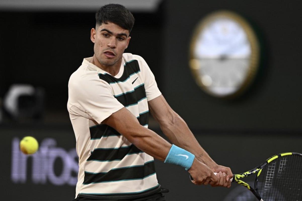 Spain's Carlos Alcaraz plays a backhand return to Hungary's Fabian Marozsan during their men's singles match on day 4 of the French Open tennis tournament on Court Philippe-Chatrier at the Roland-Garros Complex in Paris on May 28, 2025. JULIEN DE ROSA / AFP