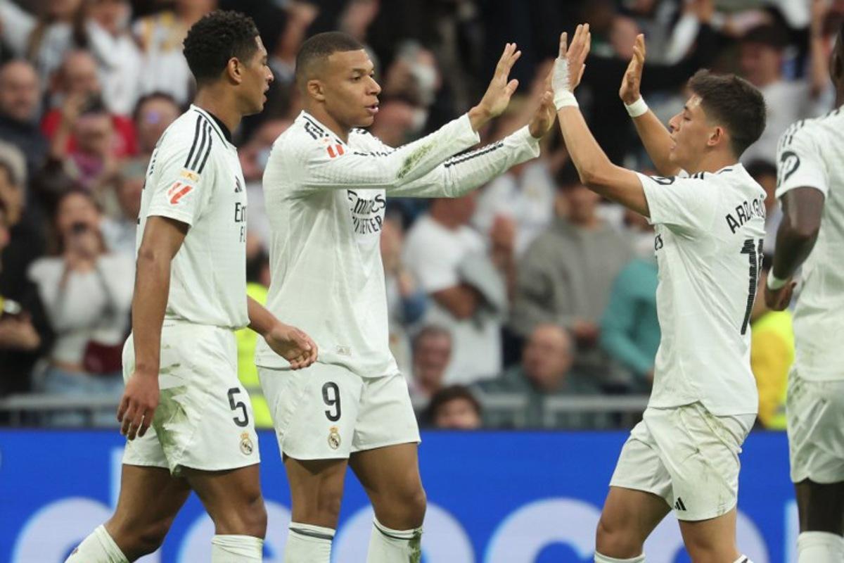 Real Madrid's French forward #09 Kylian Mbappe celebrates scoring his team's second goal, with Real Madrid's English midfielder #05 Jude Bellingham and Real Madrid's Turkish midfielder #15 Arda Guler (R), during the Spanish league football match between Real Madrid CF and RC Celta de Vigo at Santiago Bernabeu Stadium in Madrid on May 4, 2025. Pierre-Philippe MARCOU / AFP