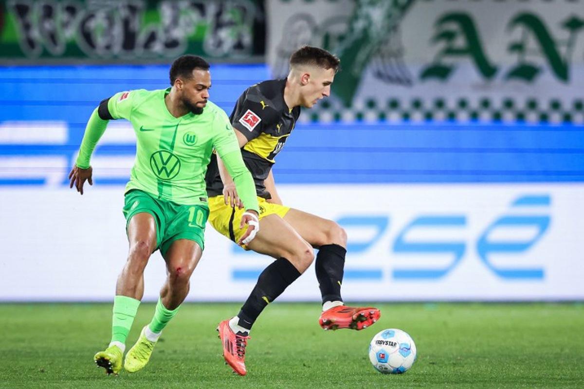 Dortmund's German defender #04 Nico Schlotterbeck (R) and Wolfsburg's German forward #10 Lukas Nmecha vie for the ball during the German first division Bundesliga football match between VfL Wolfsburg and Borussia Dortmund in Wolfsburg, northern Germany, on December 22, 2024. Ronny Hartmann / AFP