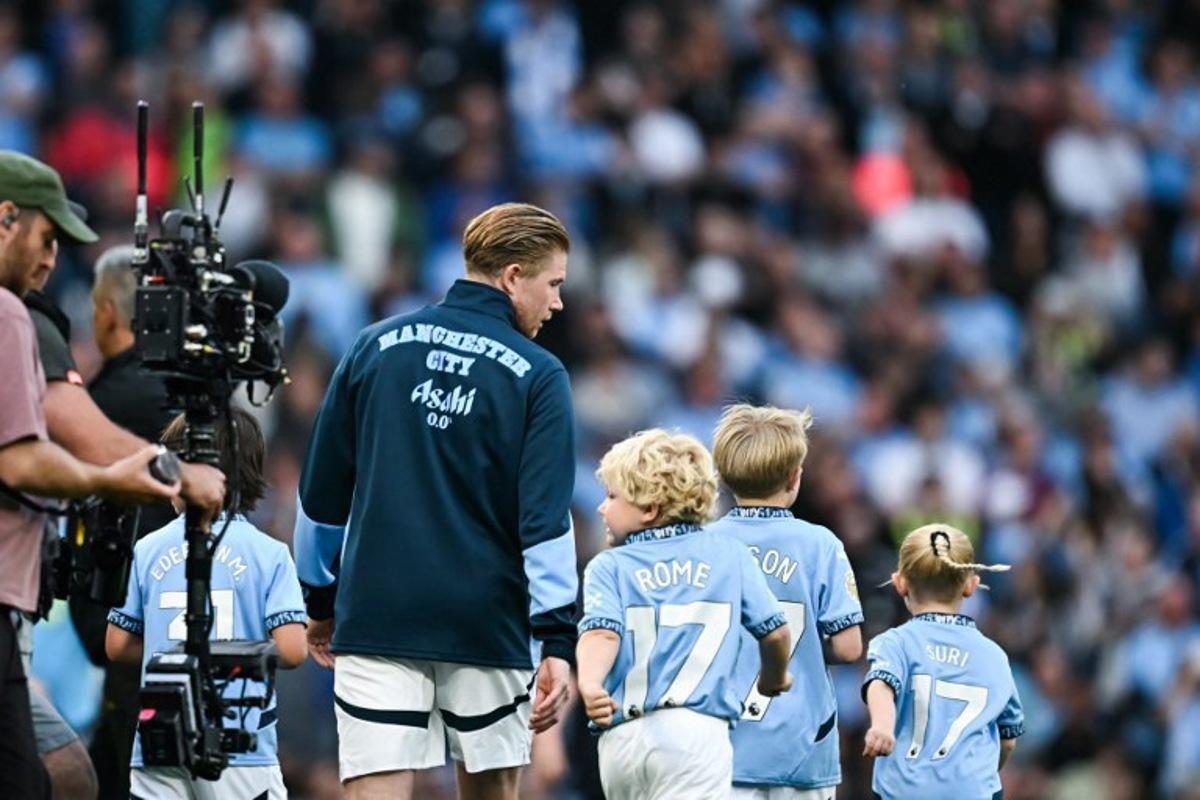 Manchester City's Belgian midfielder #17 Kevin De Bruyne (L) walks on the pitch with his children prior to the English Premier League football match between Manchester City and Bournemouth at the Etihad Stadium in Manchester, north west England, on May 20, 2025. Paul ELLIS / AFP