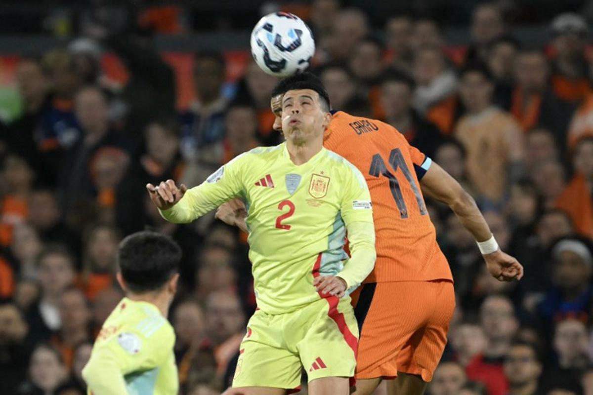 Spain's defender #02 Pedro Porro (L) jumps for the ball during the UEFA Nations League quarter-final first leg match between Netherlands and Spain at De Kuip stadium in Rotterdam, on March 20, 2025. NICOLAS TUCAT / AFP