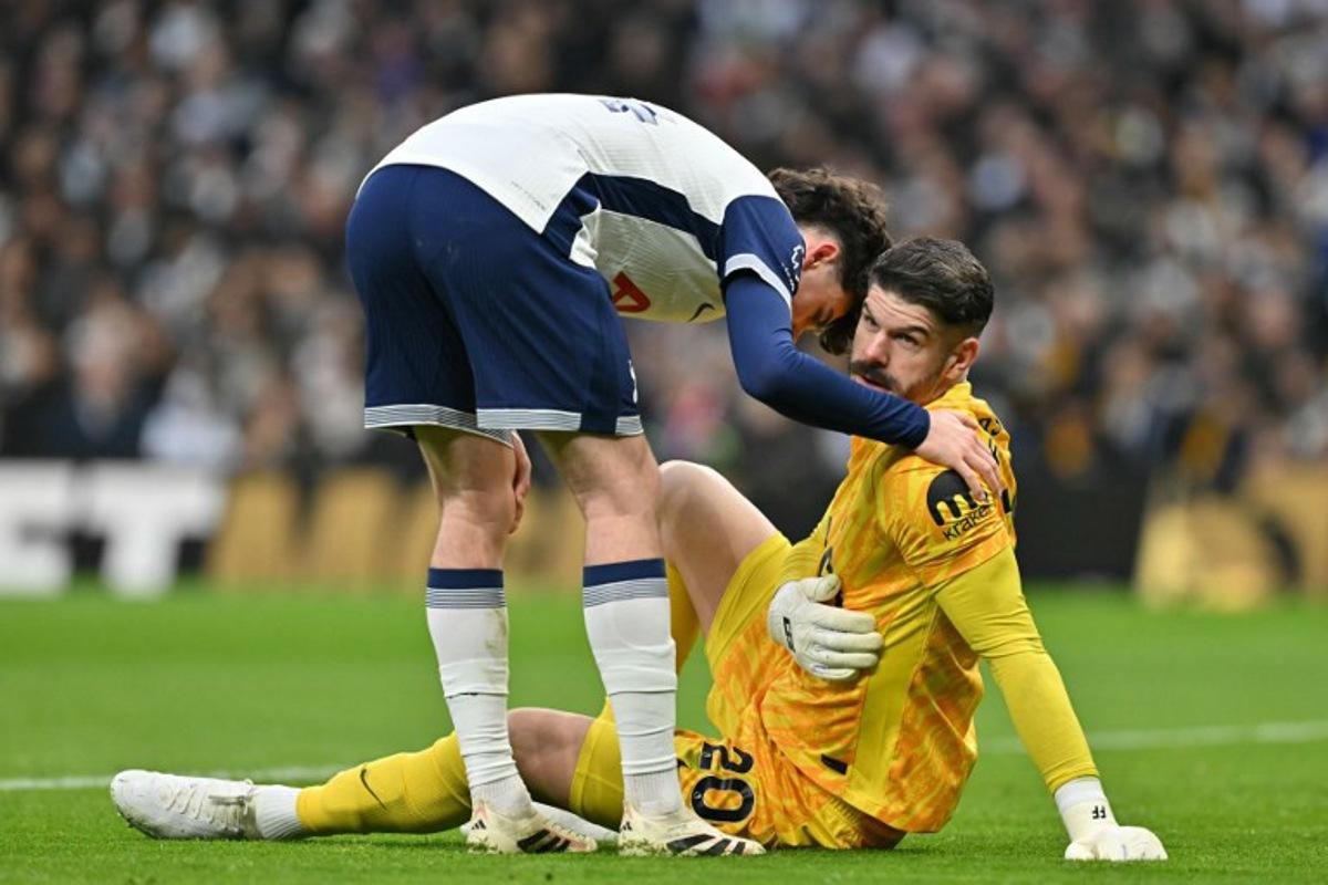 Tottenham Hotspur's English midfielder #14 Archie Gray (L) checks on Tottenham Hotspur's English goalkeeper #20 Fraser Forster (R) during the English Premier League football match between Tottenham Hotspur and Wolverhampton Wanderers at the Tottenham Hotspur Stadium in London, on December 29, 2024. Glyn KIRK / AFP