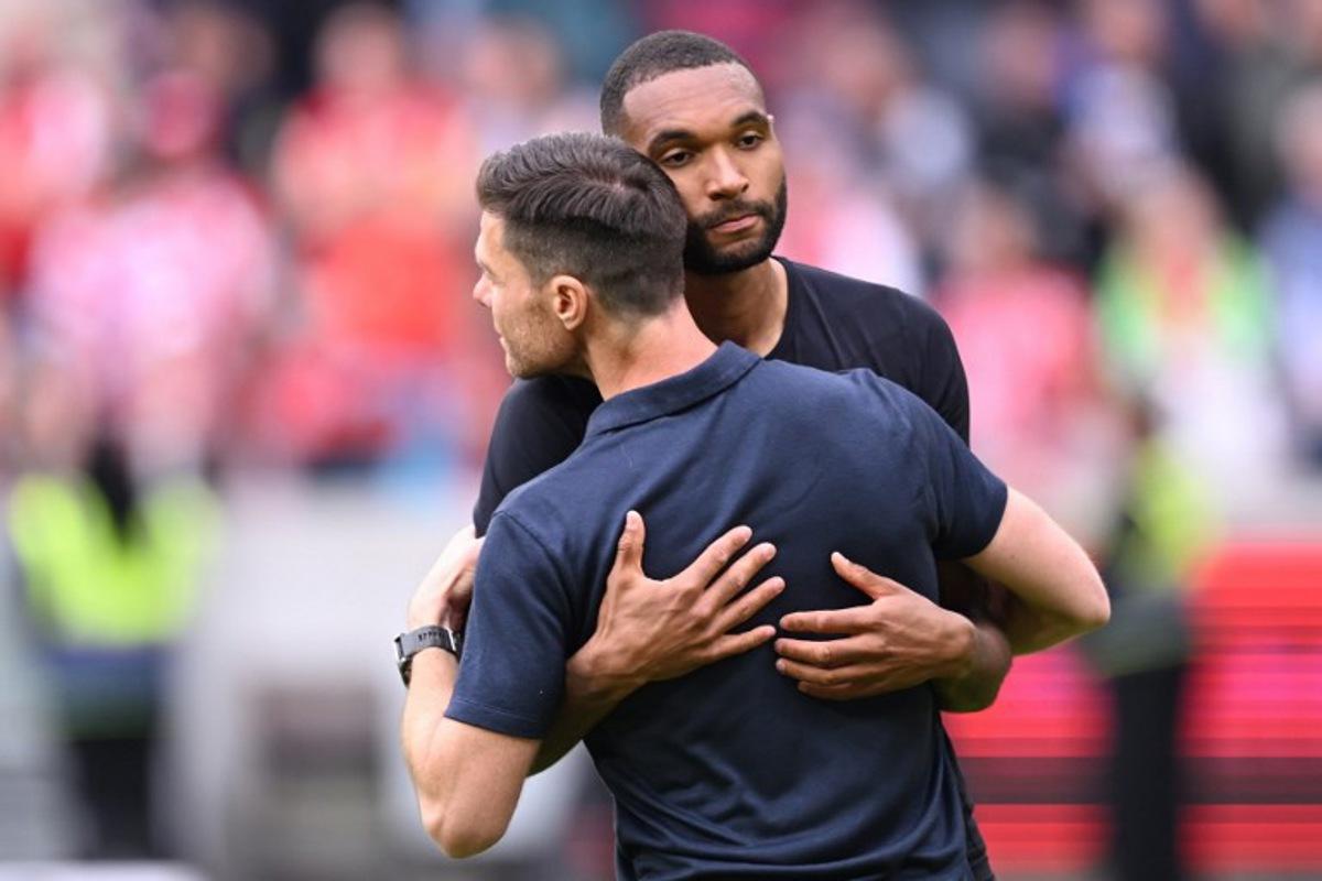 Bayer Leverkusen's Spanish head coach Xabi Alonso embraces Bayer Leverkusen's German defender #04 Jonathan Tah after the German first division Bundesliga football match between Mainz 05 and Bayer Leverkusen in Mainz, western Germany, on May 17, 2025. Kirill KUDRYAVTSEV / AFP