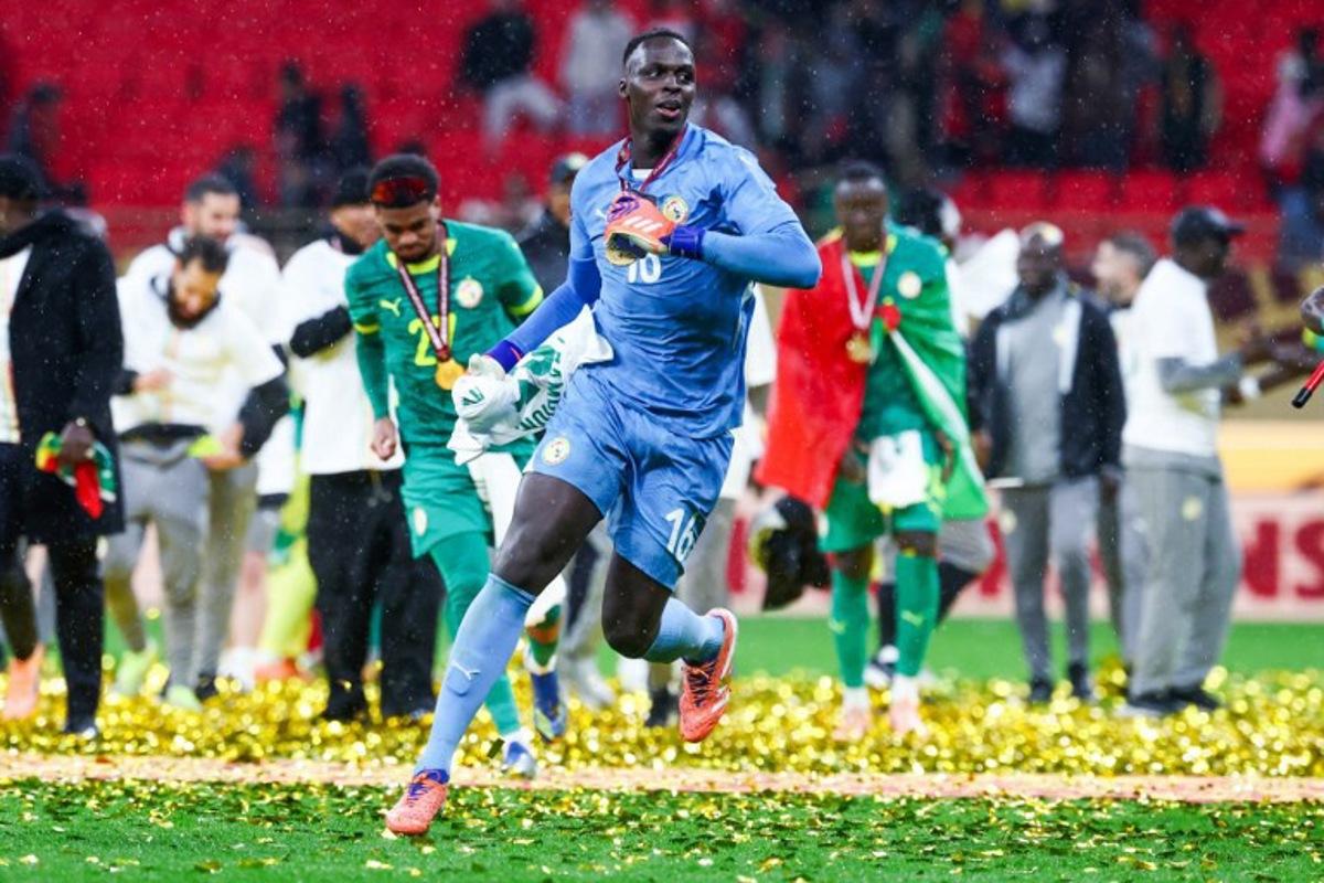 Senegal's goalkeeper #16 Edouard Mendy and his teammates celebrate their victory at the end of the Africa Cup of Nations (CAN) final football match against Morocco at the Prince Moulay Abdellah Stadium in Rabat on January 18, 2026. FRANCK FIFE / AFP