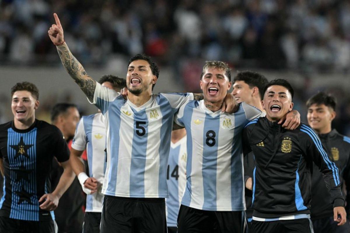 Argentina's forward #09 Julian Alvarez, Argentina's midfielder #05 Leandro Paredes, Argentina's midfielder #08 Enzo Fernandez and Argentina's midfielder #11 Thiago Almada celebrate their victory at the end of the 2026 FIFA World Cup South American qualifiers football match between Argentina and Brazil at the Mas Monumental stadium in Buenos Aires province, on March 25, 2025. JUAN MABROMATA / AFP