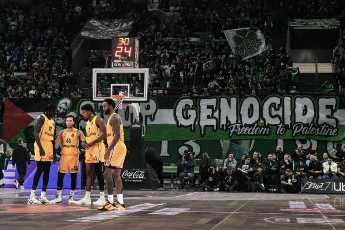 Fans of Panathinaikos hold a banner that reads "Stop Genocide. Freedom to Palestin" during the Euroleague basketball match between Panathinaikos Athens and Maccabi Tel Aviv at the OAKA stadium in Athens on November 12, 2024. Angelos TZORTZINIS / AFP