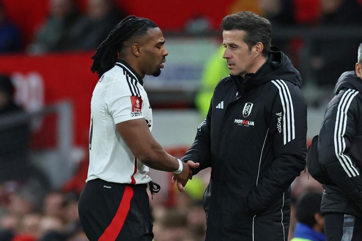 Fulham's Spanish midfielder #11 Adama Traore (L) shakes hands with Fulham's Portuguese head coach Marco Silva (R) as he leaves the game, injured during the English FA Cup fifth round football match between Manchester United and Fulham at Old Trafford in Manchester, north west England, on March 2, 2025. Darren Staples / AFP