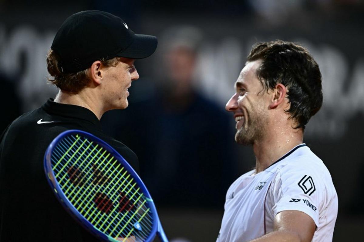 Italy's Jannik Sinner (l) celebrates at the end of his men's singles quarter-final match against Norway's Casper Ruud (r) for the ATP Rome Open tennis tournament at Foro Italico in Rome on May 15, 2025. Filippo MONTEFORTE / AFP