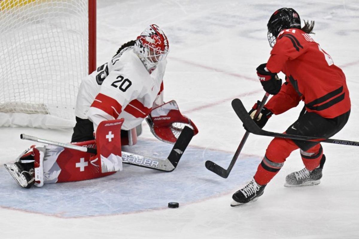 Canada's forward #40 Blayre Turnbull (R) controls the puck in front of Switzerland's goalkeeper #20 Andrea Braendli during the women's play-off semi-final ice hockey match between Canada and Switzerland at the Milano Santagiulia Ice Hockey Arena during the Milano Cortina 2026 Winter Olympic Games in Milan, on February 16, 2026. Alexander NEMENOV / AFP