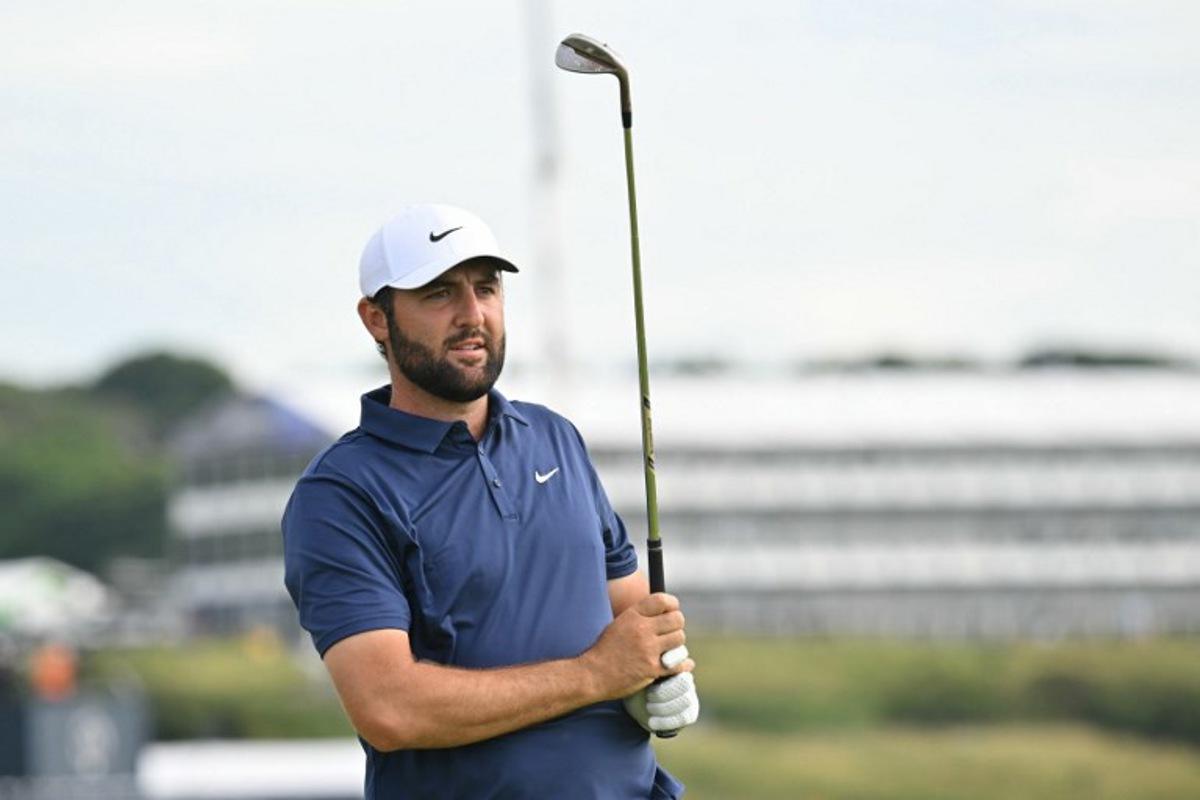 US golfer Scottie Scheffler watches his approach shot from the 15th fairway on day four of the 153rd Open Championship at Royal Portrush golf club in Northern Ireland on July 20, 2025. ANDY BUCHANAN / AFP