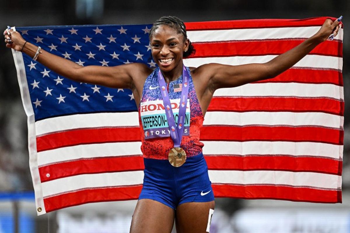 US' athlete Melissa Jefferson-Wooden celebrates with her country's flag after winning the women's 100m final during the World Athletics Championships in Tokyo on September 14, 2025. Jewel SAMAD / AFP