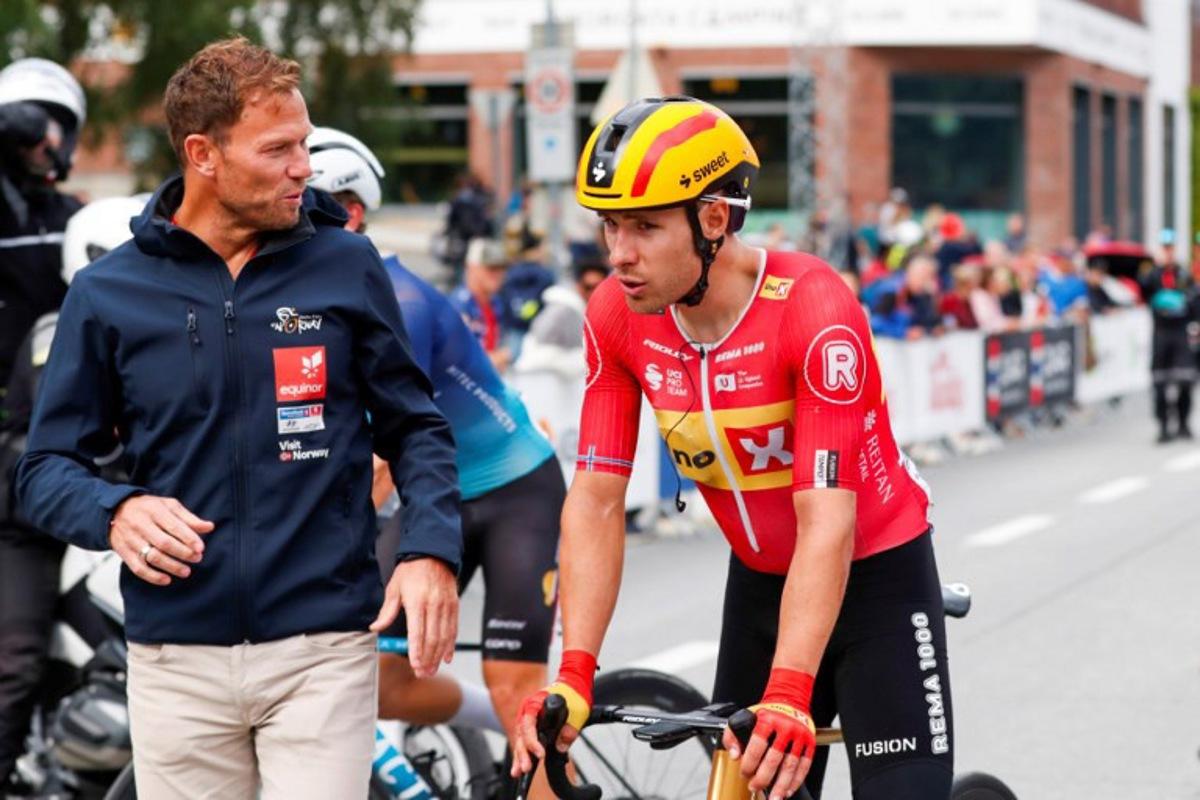 Uno-X Pro Cycling Team's Norwegian rider Fredrik Dversnes (R) is welcomed by Uno-X Mobility's CEO Thor Hushovd (L) after winning the fourth and final stage of the Arctic Cyling Race 2025 in Tromso, Norway, on August 10, 2025. Rune Stoltz Bertinussen / NTB / AFP