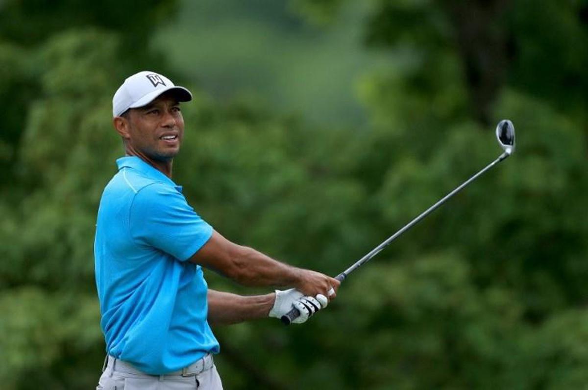 (FILES) In this file photo taken on July 16, 2020 Tiger Woods of the US plays his shot from the fifth tee during the first round of The Memorial Tournament in Dublin, Ohio. Woods said on December 8, 2021, he will make his return to competitive golf at next week's PGA Tour PNC Championship in Florida. The former world number one, who has not played since suffering career-threatening leg injuries in a car crash in Los Angeles in February, will play in the December 16-19 tournament alongside his son Charlie. Sam GREENWOOD / GETTY IMAGES NORTH AMERICA / AFP