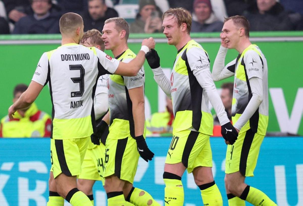 Dortmund's German midfielder #10 Julian Brandt (2R) celebrates with teammates scoring his team's first goal during the German first division Bundesliga football match between VfL Wolfsburg and Borussia Dortmund in Wolfsburg, on February 7, 2026. Ronny HARTMANN / AFP