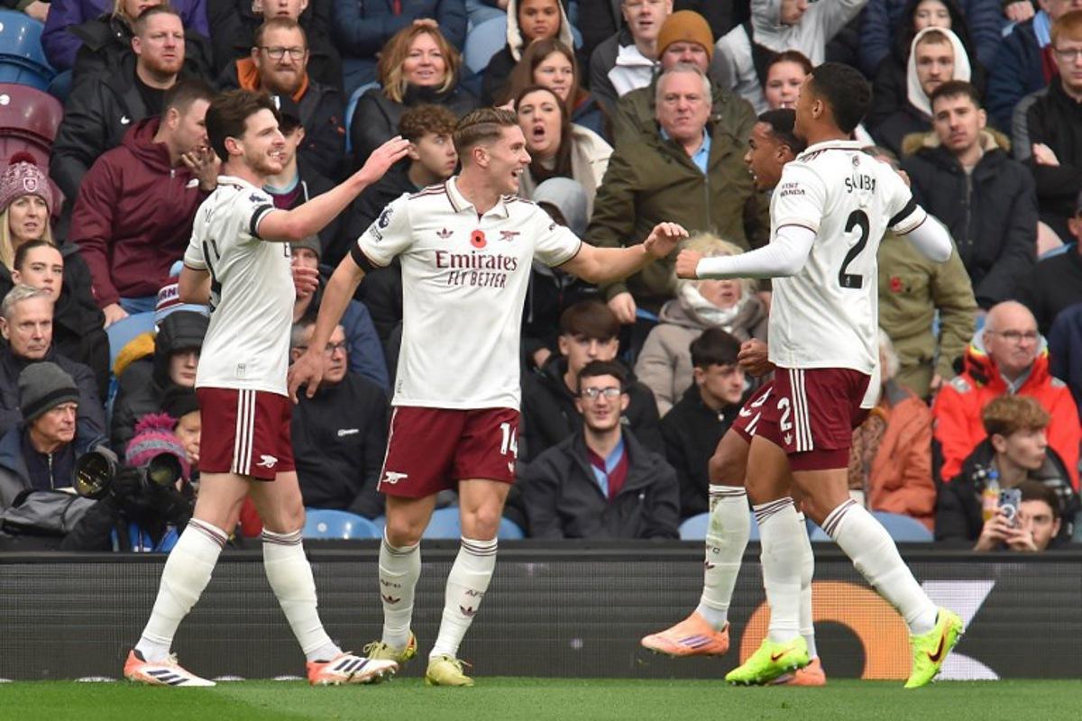 Arsenal's Swedish striker #14 Viktor Gyokeres (C) celebrates with teammates after scoring the opening goal of the English Premier League football match between Burnley and Arsenal at Turf Moor in Burnley, north-west England on November 1, 2025. PETER POWELL / AFP