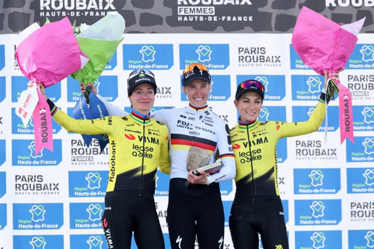 (From L) Second-placed Team Visma - Lease a Bike's Dutch rider Marianne Vos, first-placed FDJ United-SUEZ's German rider Franziska Koch and third-placed Team Visma - Lease a Bike's French rider Pauline Ferrand-Prévot celebrate on the podium of the 6th edition of the Women Paris-Roubaix one-day classic cycling race, 143.1 km between Denain and Roubaix, at the Vélodrome André-Pétrieux in Roubaix, northern France, on April 12, 2026. Francois LO PRESTI / AFP