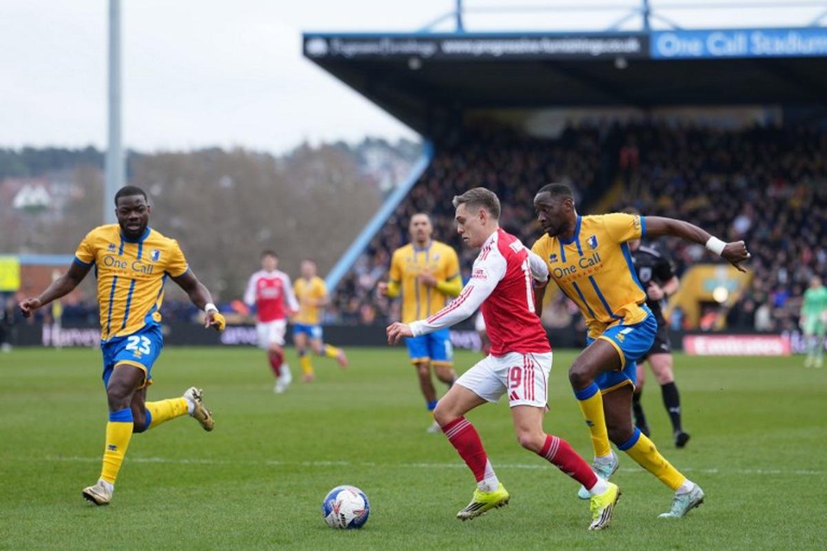 Arsenal's Belgian midfielder #19 Leandro Trossard (C) takes on the Mansfield defence during the English FA Cup fifth round football match between Mansfield Town and Arsenal at the One Call Stadium, Field Mill in Mansfield, central England on March 7, 2026. Jon Super / AFP