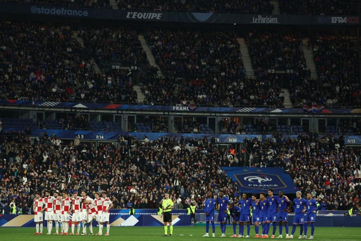 Croatia's players (L) and France's players (R) stand as they watch the penalty shoot-out during the UEFA Nations League quarter-final second-leg football match between France and Croatia at the Stade de France in Saint-Denis, north of Paris, on March 23, 2025. FRANCK FIFE / AFP